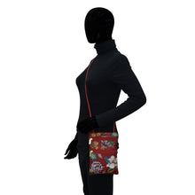 Load image into Gallery viewer, A mannequin dressed in a black bodysuit with a colorful, hand-painted Anuschka Mini Double Zip Travel Crossbody - 448 around its waist.
