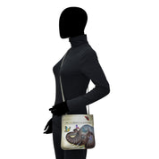 Mannequin with an Anuschka Slim Crossbody With Front Zip - 452 tote bag featuring hand painted artwork.