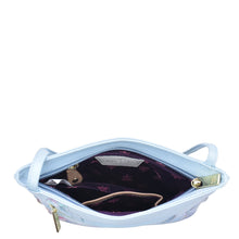 Load image into Gallery viewer, Light blue Anuschka Slim Crossbody With Front Zip - 452 with a floral-patterned interior, partially open, showing contents inside against a white background.
