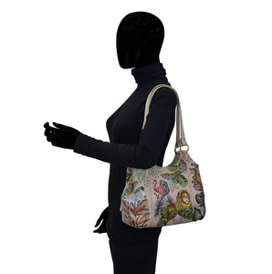 Mannequin with a patterned, hand-painted Anuschka Triple Compartment Satchel - 469 displaying a side profile.