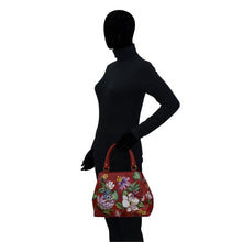 Load image into Gallery viewer, Silhouetted figure holding a brightly colored floral, Anuschka Multi Compartment Satchel - 690.
