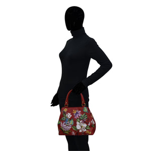 Silhouetted figure holding a brightly colored floral, Anuschka Multi Compartment Satchel - 690.