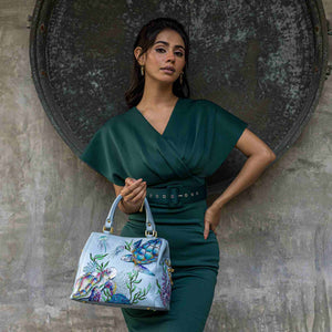Woman in a green dress posing with an Anuschka Multi Compartment Satchel - 690.