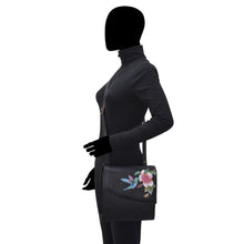 Load image into Gallery viewer, Mannequin displaying a black outfit with a Anuschka Flap Messenger Crossbody - 692 purse with floral leather.
