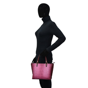 Mannequin in a black turtleneck holding an Anuschka Medium Tote - 693 with an adjustable handle.