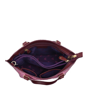 An open, empty burgundy Anuschka Medium Tote - 693 handbag with a patterned interior.