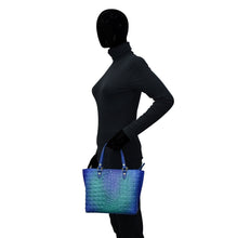 Load image into Gallery viewer, Sentence with replaced product: Silhouetted figure holding an Anuschka Medium Tote - 693.
