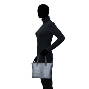 A silhouette of a person carrying an Anuschka Medium Tote - 693, set against a white background.