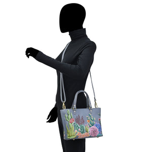 Person standing with a Anuschka Medium Tote - 693 bag over their shoulder.