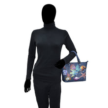Load image into Gallery viewer, Mannequin wearing a black turtleneck and gloves, holding a Anuschka Medium Tote - 693 with a marine life design.
