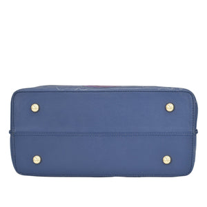Blue rectangular Anuschka genuine leather Medium Tote - 693 laying on its side with protective metal studs.