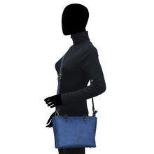 Load image into Gallery viewer, Silhouette of a person holding a blue leather Anuschka Medium Tote - 693.
