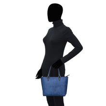 Load image into Gallery viewer, Silhouetted profile of a woman holding an Anuschka Medium Tote - 693 with hand-painted artwork.
