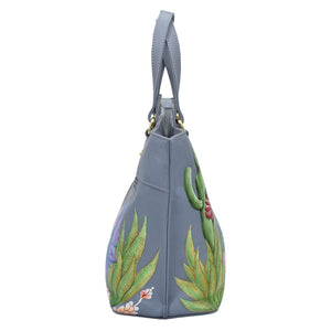 Side view of a gray Anuschka Medium Tote - 693 with green leaf and cactus hand-painted embroidery.