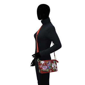 Mannequin displaying a red blazer and an organized Anuschka Triple Compartment Crossbody - 696 floral purse against a white background.