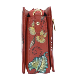 Side view of a red hand-painted leather Anuschka purse with floral and leaf designs, featuring organized triple compartments.