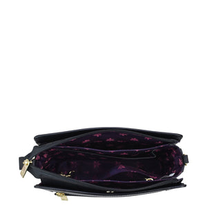An open black Triple Compartment Crossbody - 696 handbag by Anuschka displaying a purple interior with a floral pattern and multiple compartments.