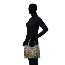 Load image into Gallery viewer, Mannequin wearing a black bodysuit and holding an Anuschka Medium Satchel - 697 with a colorful, Italian-inspired design.
