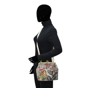 Sentence with replaced product:
A mannequin dressed in a black outfit with a full head cover, holding an Anuschka Medium Frame Crossbody - 700 with animal print design and genuine leather.