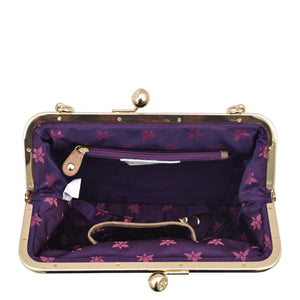 Inside view of an open, empty Anuschka Medium Frame Crossbody - 700 with purple lining and a floral pattern in a vintage-inspired, structured style.