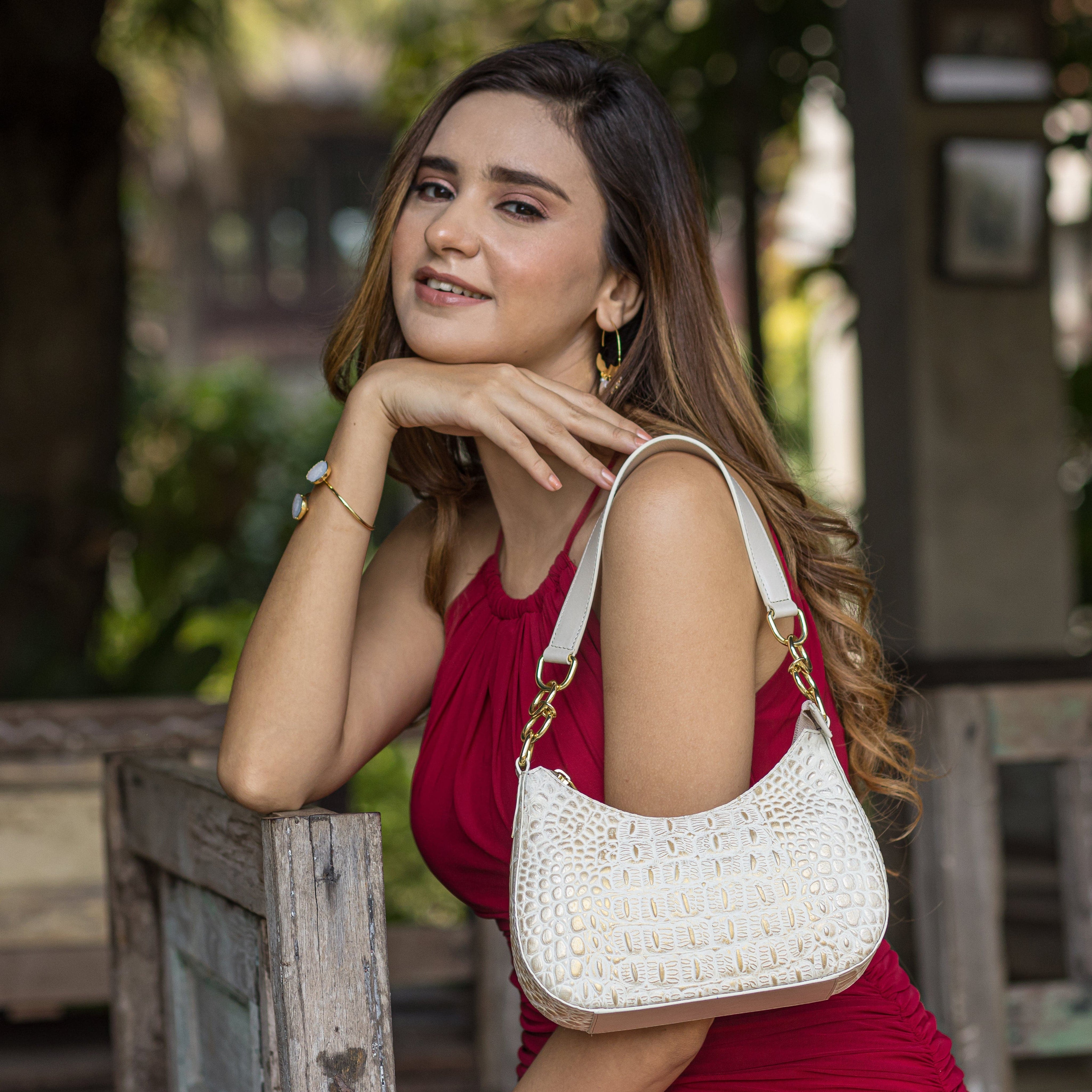 A woman in a red dress posing with a white Anuschka Small Convertible Hobo - 701.
