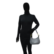 Load image into Gallery viewer, Mannequin dressed in black with a face covering holding a gray Anuschka Small Convertible Hobo - 701 genuine leather handbag with a crossbody strap.

