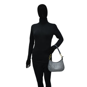 Mannequin dressed in black with a face covering holding a gray Anuschka Small Convertible Hobo - 701 genuine leather handbag with a crossbody strap.