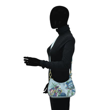 Load image into Gallery viewer, Mannequin with a black hoodie and gloves carrying an Anuschka Small Convertible Hobo - 701, isolated on a white background.
