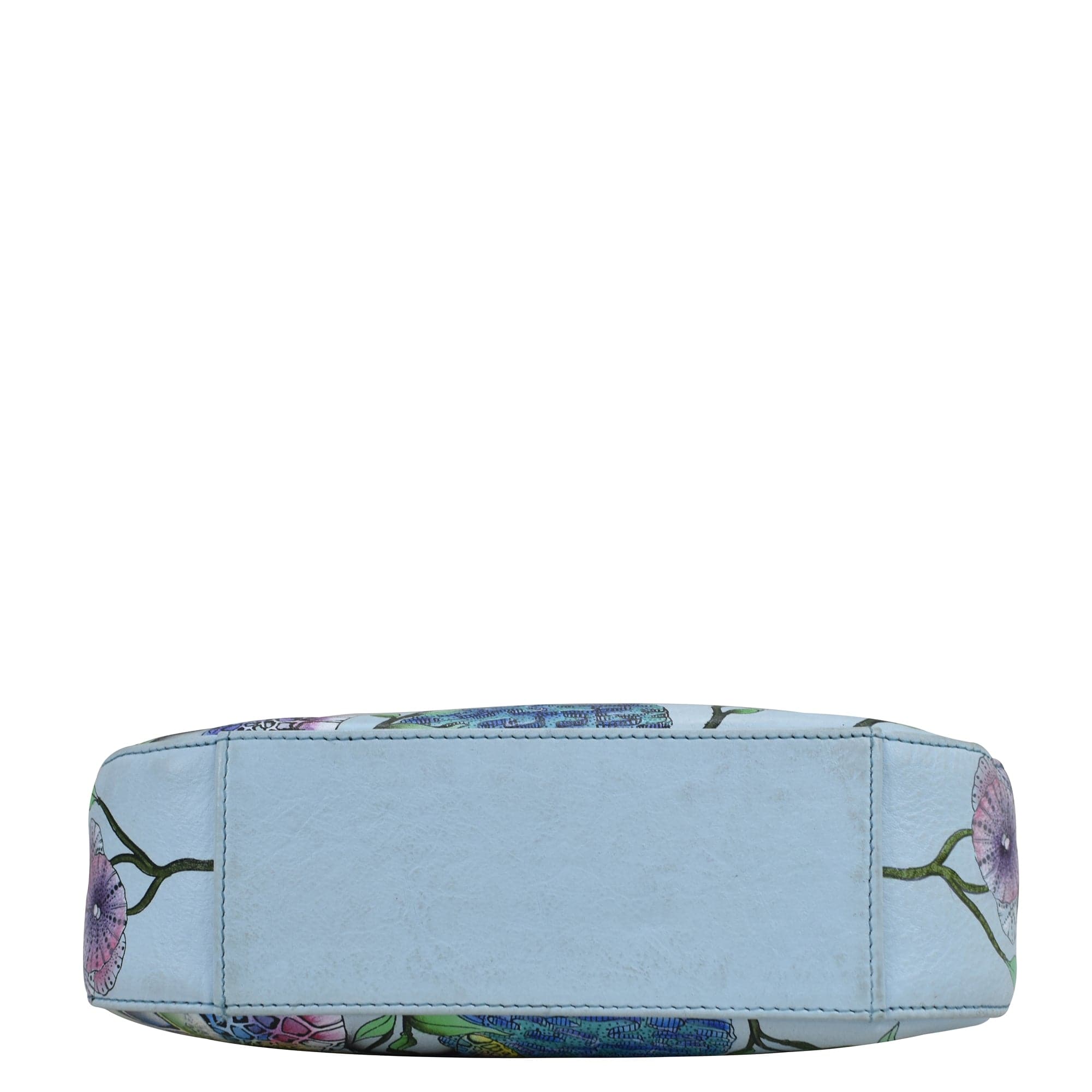 Side view of a light blue Anuschka Small Convertible Hobo - 701 with a floral pattern, rolled up and isolated on a white background.