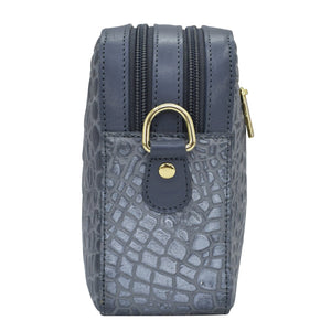 Vertical standing Anuschka Twin Top Messenger - 704 with a textured pattern, gold-tone hardware, and an adjustable strap.