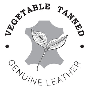Logo depicting an Anuschka Accordion Flap Wallet - 1174 made of vegetable-tanned genuine leather with RFID protection, featuring an illustration of a leaf and a leather hide shape.